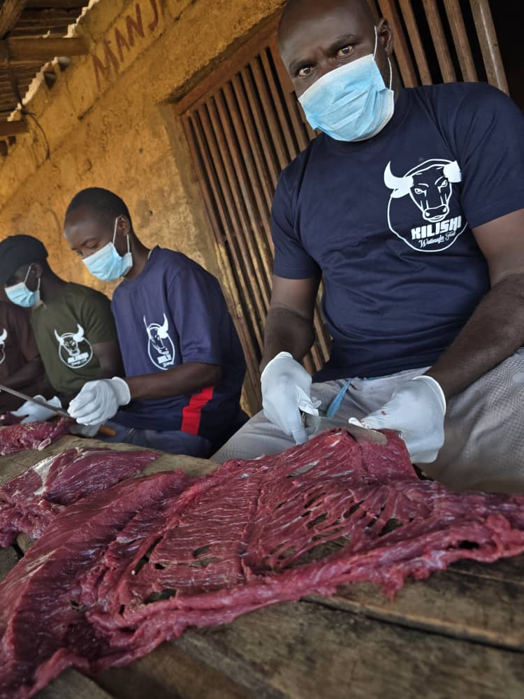 Master butchers hand-slicing lean beef sheets on the production line in Northern Nigeria