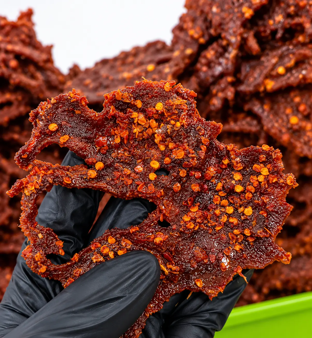 Close-up texture of artisanal sun-cured Northern Kilishi with chilli pepper and spices
